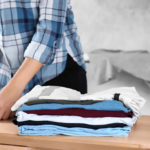Navigating home care for a disability during COVID-19. Home health aide folding laundry.